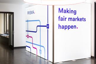 Photo of a glowing stand up display with the copy "Making fair markets happen."