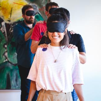 blindfolded people playing a trust game